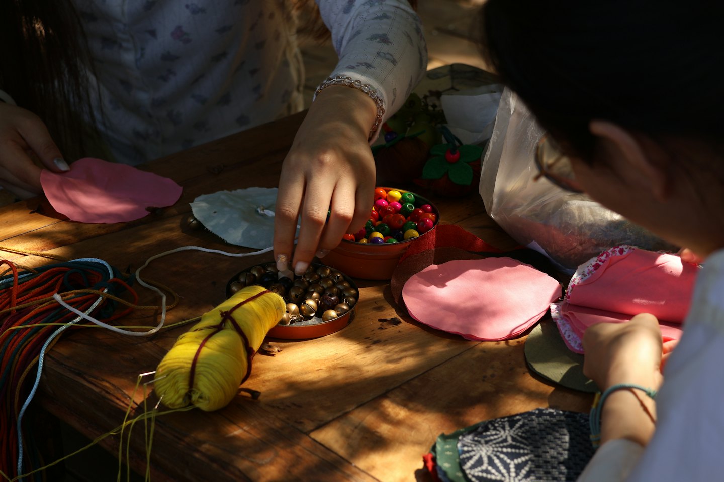 People working together on craft projects at a wooden table.
